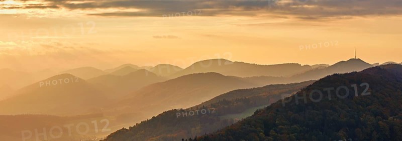 View of an autumnal forest from the Gisliflue, behind the Jurassic foothills with the water fluh in the light of the setting sun, Talheim, Canton, Aargau, Switzerland
