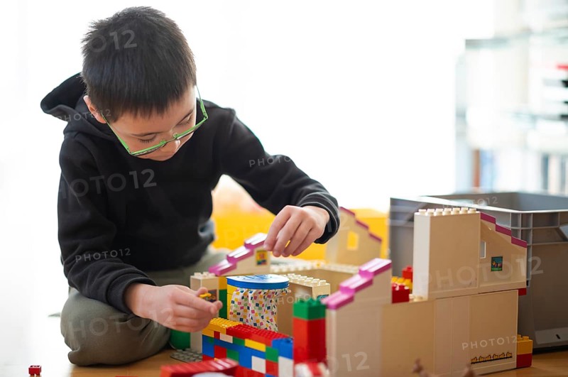 Boy, 6 years, glasses, multi-ethnic, plays with Lego, concentrates, constructs, builds, Stuttgart, Baden-Württemberg, Germany
