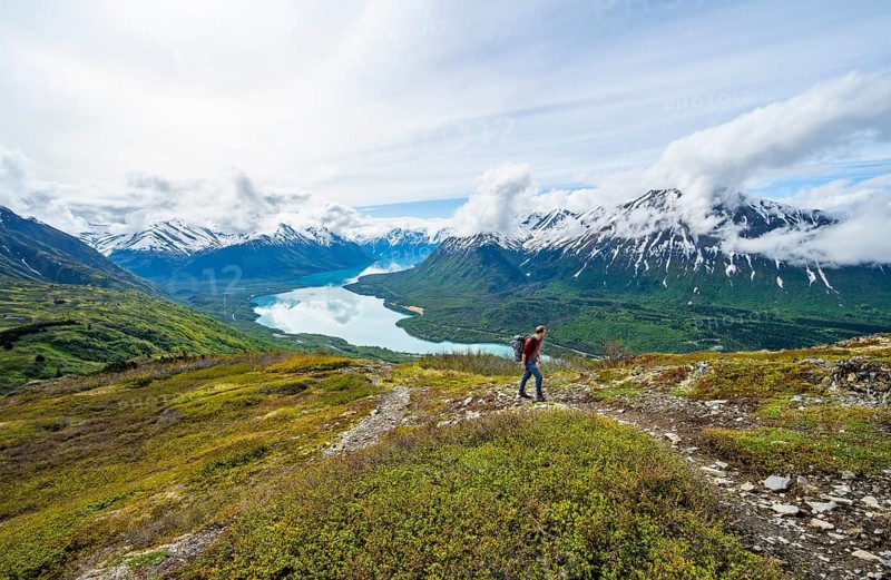 Climbers on a hiking trail, Slaughter Ridge Trail, view of snowy mountains and turquoise lake Kenai Lake, Cooper Landing, Kenai Peninsula, Alaska, USA