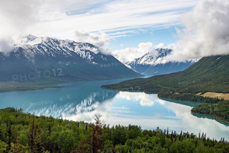 View of snowy mountains in spring and turquoise Kenai Lake with reflection, Slaughter Ridge Trail, Cooper Landing, Kenai Peninsula, Alaska, USA