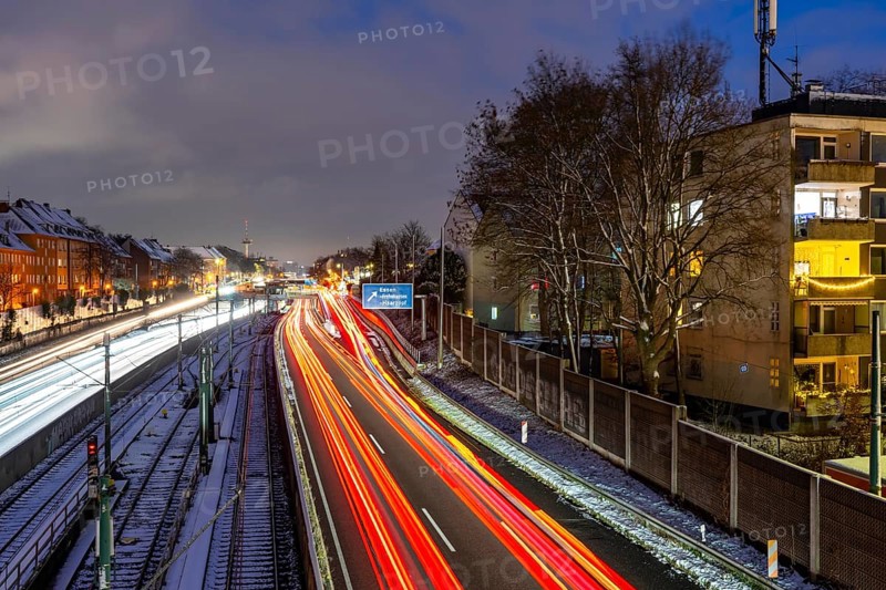 Autobahn A40, Ruhrschnellweg, near Essen at the Frohnhausen junction, evening traffic in winter, residential buildings directly on the 4-lane motorway, North Rhine-Westphalia, Germany