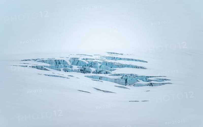 Smooth white snowy area on the glacier broken by crevasses with blue rugged glacial ice, detail, Exit Glacier, Kenai Peninsula, Alaska, USA