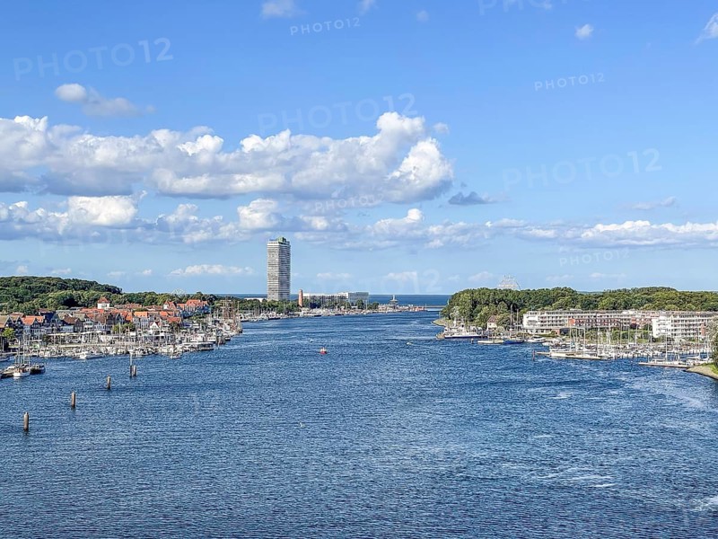 View over the Trave towards the mouth in the underground, the church of Travemünde and the Atlantic Hotel, with clouds and birds, Travemünde, Lübeck, Schleswig-Holstein, Germany
