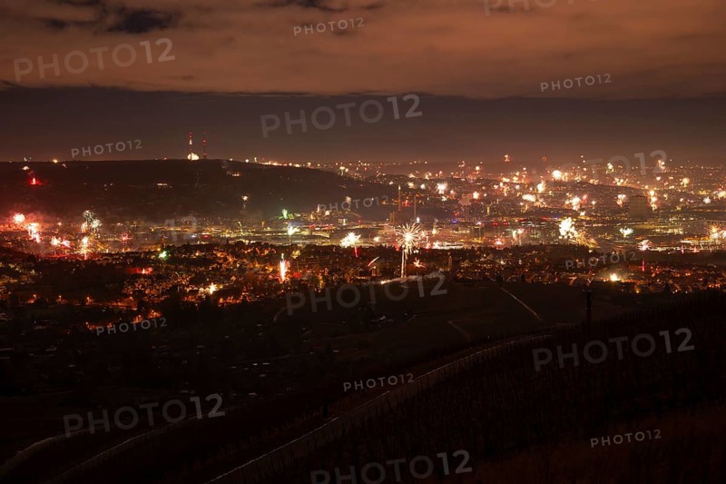 View from Kapellberg near Fellbach across the Neckar Valley to Stuttgart on New Year's Eve from 2025 to 2026. The television tower on the horizon as firecrackers and rockets light up the night sky at the turn of the year and greet the new year