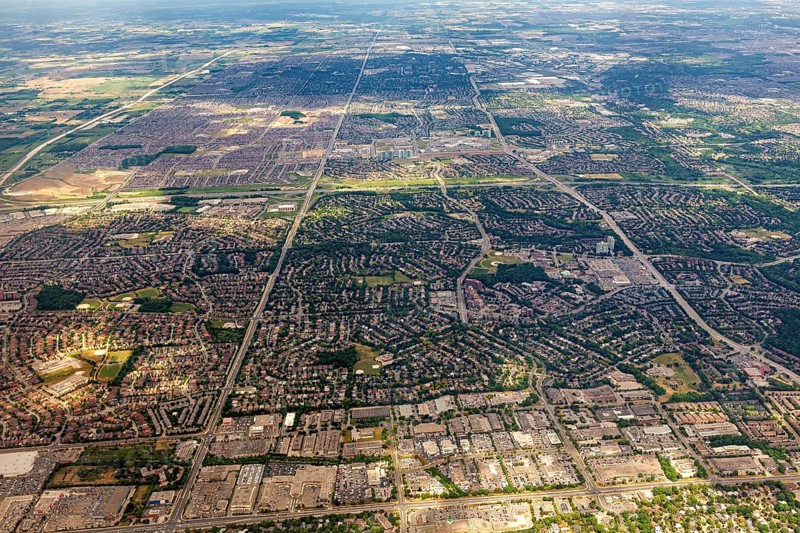Vast urban areas with a distinctive striped pattern under a blue sky, view from an airplane of the suburbs of Toronto in Canada