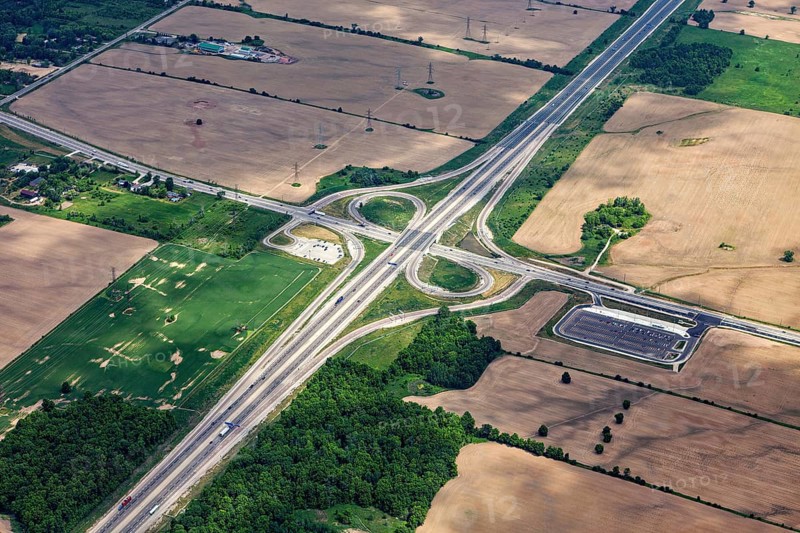 A large road junction surrounded by fields and green spaces, visible from the air, view from an airplane of the suburbs of Toronto in Canada
