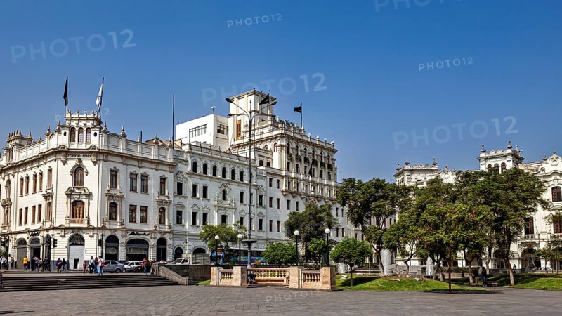 Impressive colonial building on an open square with trees and clear sky, Downtown Lima in Peru