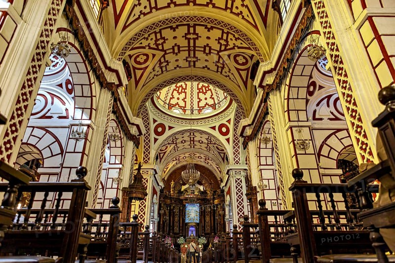 Sumptuous church interior with ornate ceilings and red patterns, The Basilica of St. Francis in downtown Lima in Peru