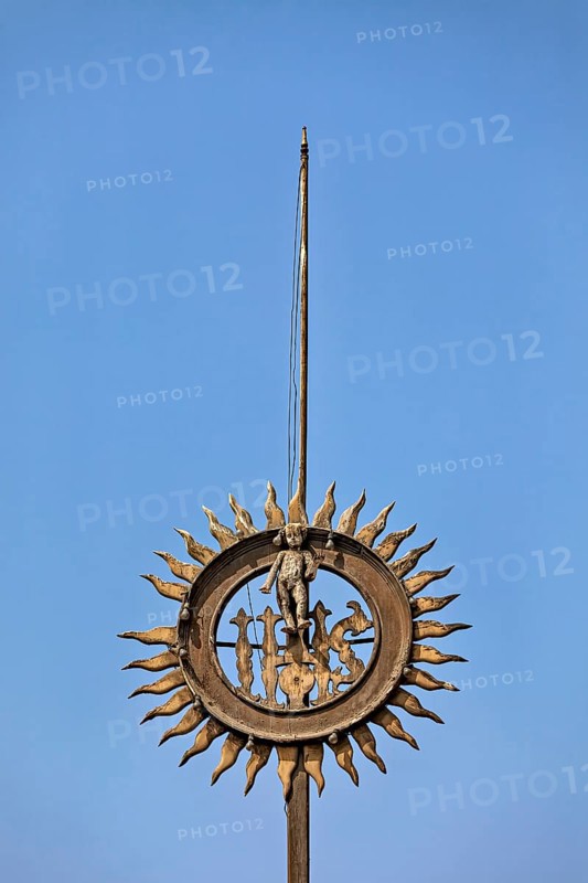 Metal sculpture with sun motif against clear blue sky, reliefs at the Basilica of St. Francis in Lima in Peru