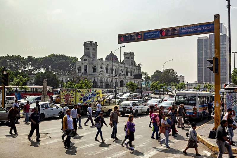 Urban street scene with pedestrians and traffic in front of historic buildings, Downtown Lima in Peru