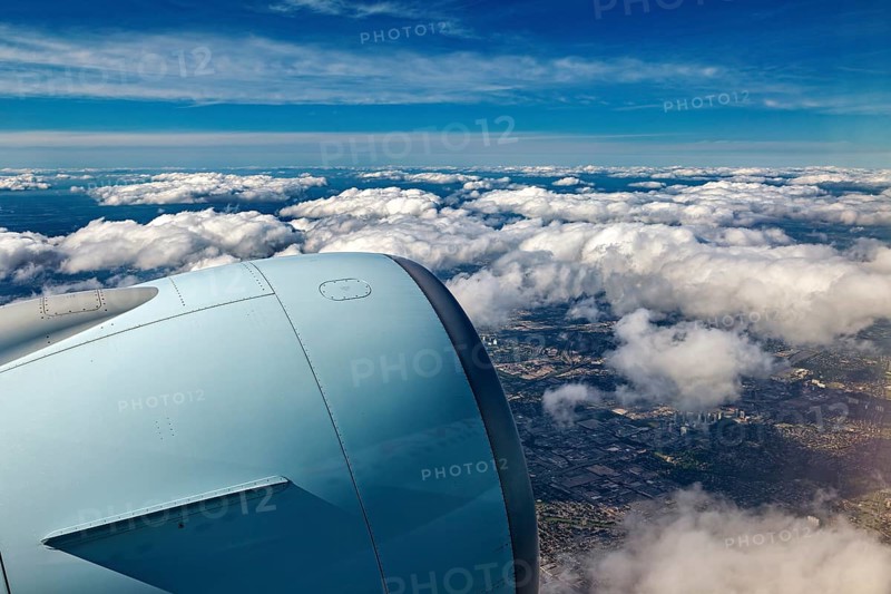 Aircraft engine above clouds overlooking the city, In an airplane above the clouds