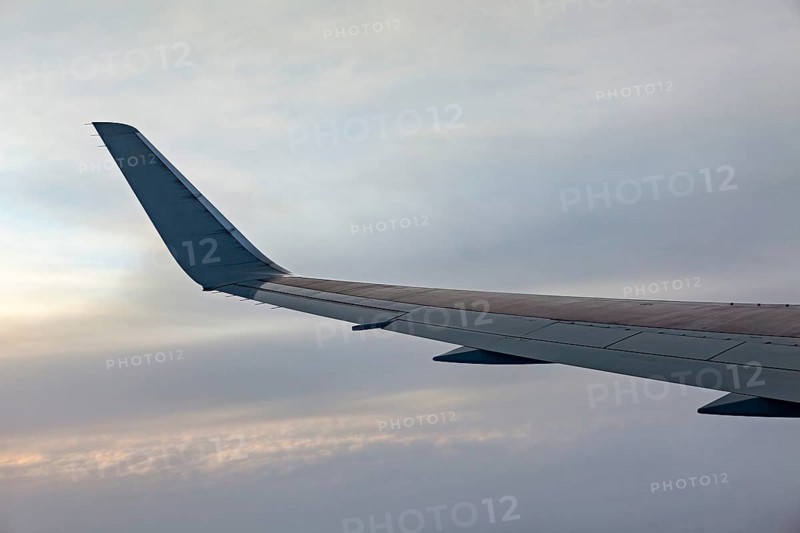 Close-up of airplane wing against grey sky, On an airplane above the clouds