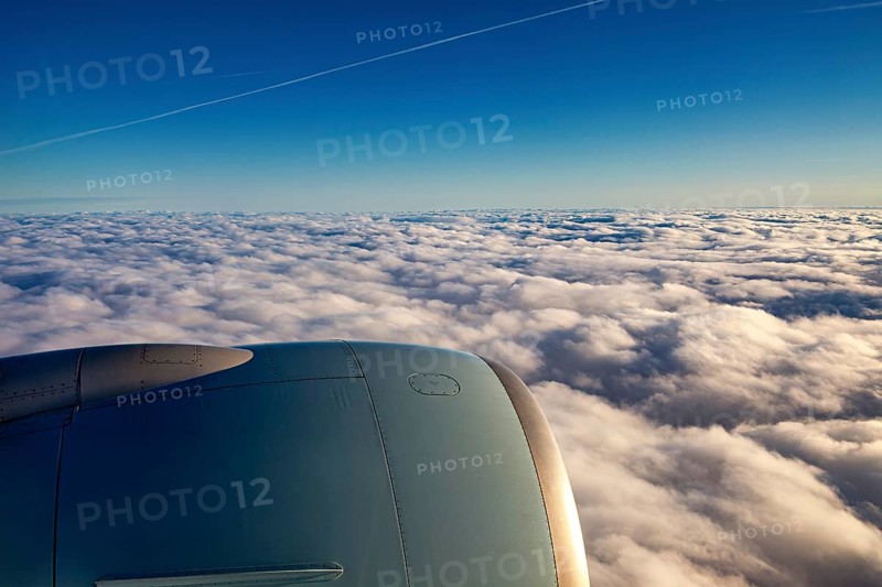 View of aircraft engine above white clouds under blue sky, On an airplane above the clouds