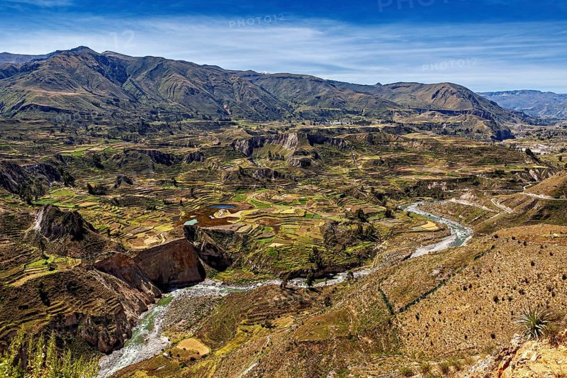 Extensive landscape with terraces and a river in mountainous surroundings, The landscape of the Colca Canyon in the Andes of Peru