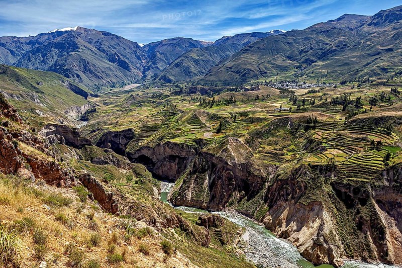Valley with terraced fields surrounded by mountains and a river, The landscape of the Colca Canyon in the Andes of Peru