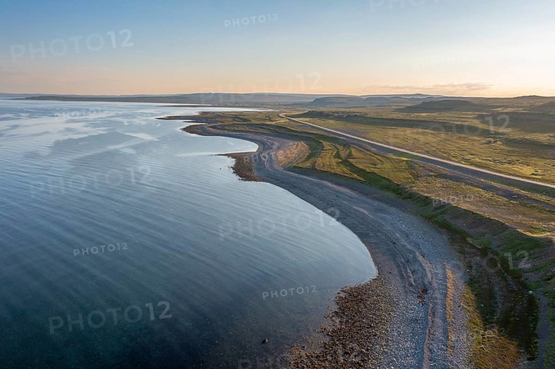 Coastal landscape on Varangerfjord with blue sky, still sea, moors and pebble beach aerial view, Barents Sea, Finnmark, Norway