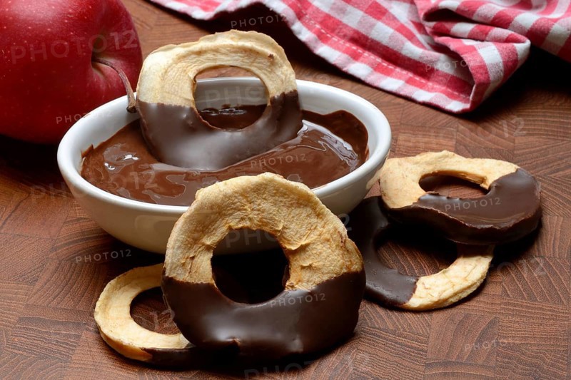 Apple rings, coated with chocolate, chocolate glaze in bowl