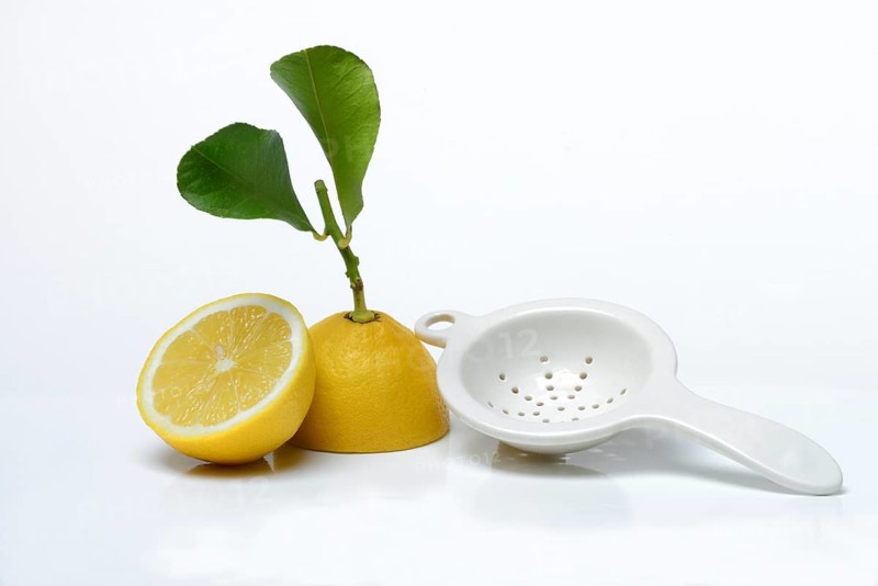 Lemon with leaf, cut in half, Citrus x limon, porcelain strainer
