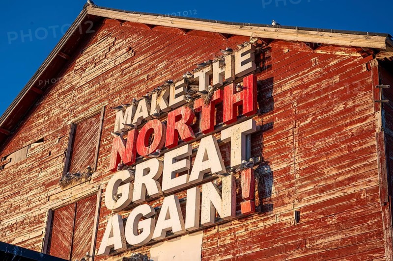 Red fishing building with the inscription Make the North great again at Vardö harbour, Vardø, Finnmark, Norway