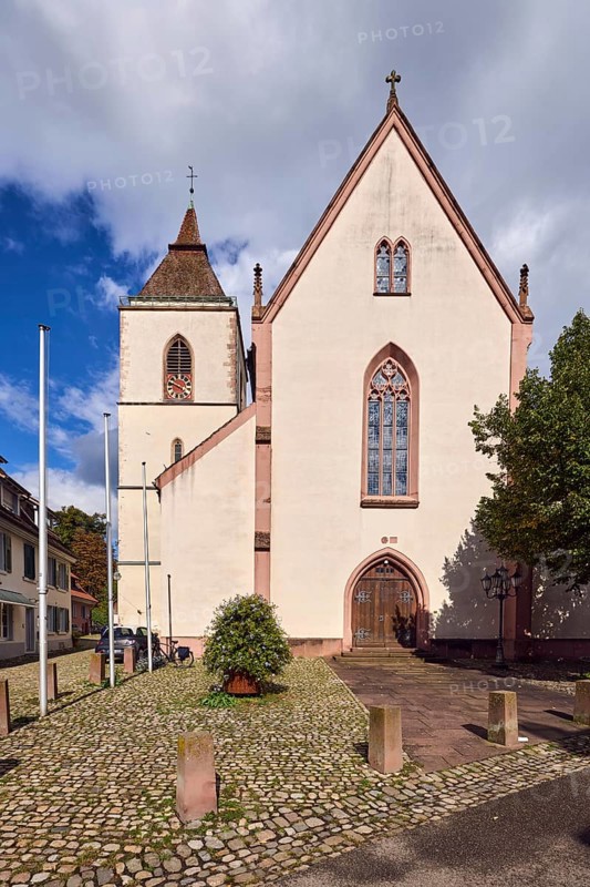 St. Martin parish church, neo-Gothic style, church tower, church tower clock, flagpoles, barrier bollards, entrance door, church window, trees, blue sky, cumulus clouds, Kirchstraße street, Staufen im Breisgau, Black Forest, Breisgau-Hochschwarzwald district, Baden-Württemberg, Germany