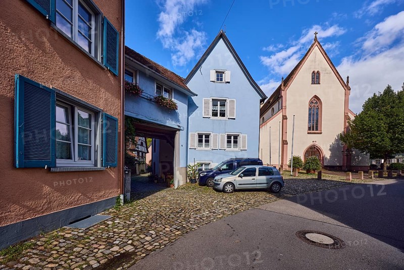 St. Martin parish church, houses, historic residential buildings, multi-family houses, road, curve, cars, trees, blue sky, cumulus clouds, Kirchstraße, Staufen im Breisgau, Black Forest, Breisgau-Hochschwarzwald district, Baden-Württemberg, Germany