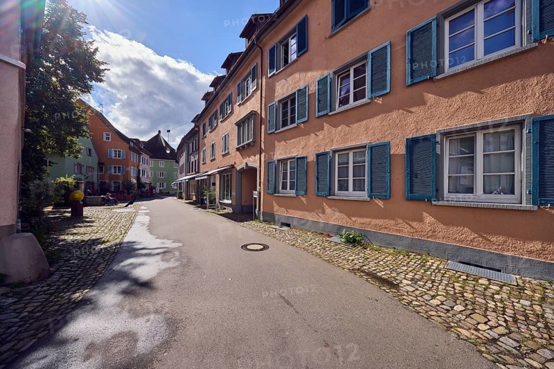 Historic residential and commercial buildings, apartment building, general architecture, façade with windows, shutters and awnings, shopping, trees, pedestrians as accessories, sun backlight, blue sky, cumulus clouds, Kirchstraße street, Staufen im Breisgau, Black Forest, Breisgau-Hochschwarzwald district, Baden-Württemberg, Germany