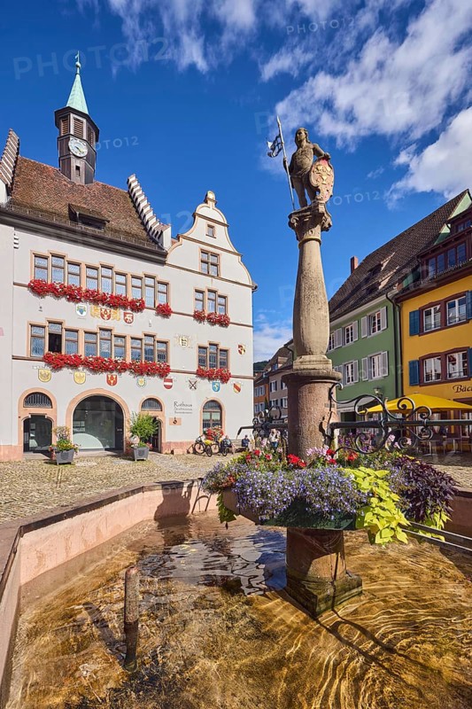 Market fountain, historic town hall, general architecture, houses, cobblestone square, trees, blue sky, cumulus clouds, intersection of main street with Kirchstraße, Staufen im Breisgau, Black Forest, Breisgau-Hochschwarzwald district, Baden-Württemberg, Germany