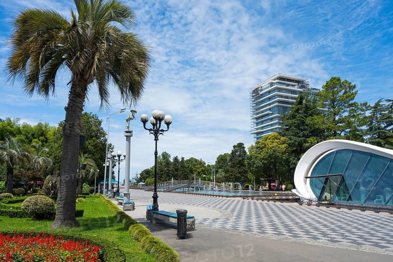 Palm trees and street lamps along a modern walkway in the urban landscape with fountain, right registry office, Batumi Boulevard, Batumi, Black Sea, Ajara region, Adjara, autonomous republic, Georgia