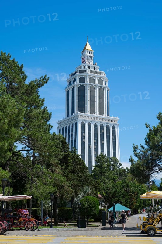 Tall white building in the park with carriages in the foreground and clear sunny sky, Sheraton Hotel, Batumi, Black Sea, Ajara Region, Adjara, Autonomous Republic, Georgia