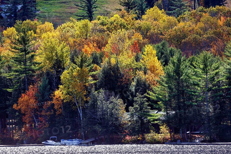 Cottage on the shore of a lake, motor boat, boat dock, autumn leaves, Indian Summer, Maine, New England, USA
