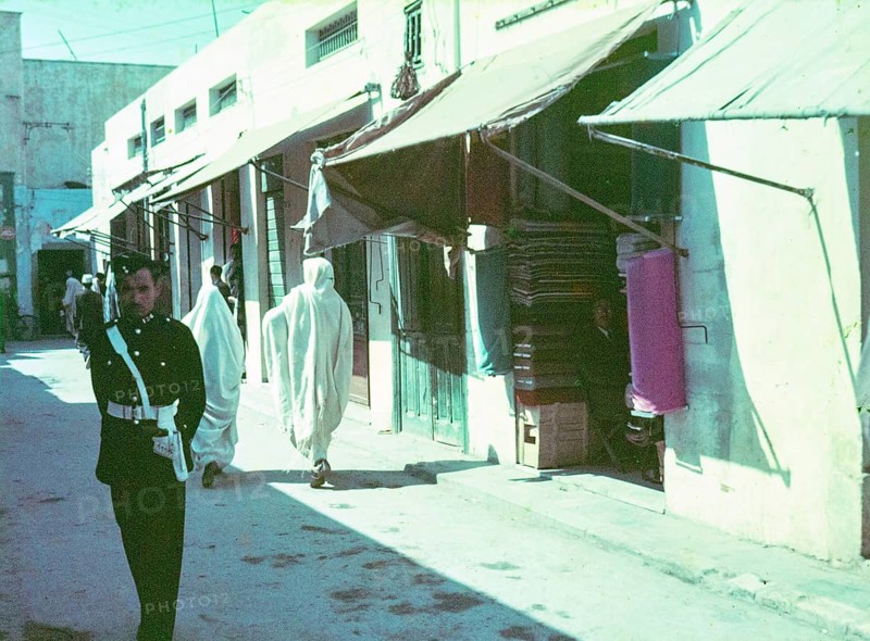 Policeman standing in street of small shops in souk of old town medina, Tripoli, Libya, North Africa 1956
