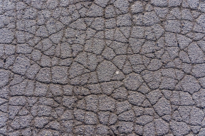 Asphalt surface, floor, with many small cracks, roadway, parking lot