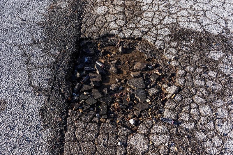 Pothole, asphalt surface, floor, with many small cracks, roadway, parking lot