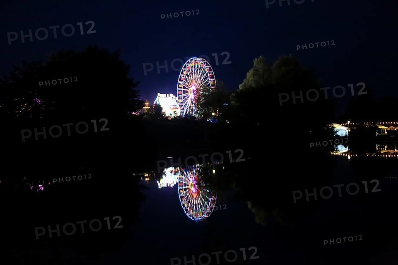 Fairground in Ulm Friedrichsau at night, folk festival, hustle and bustle, fair, Ferris wheel, amusement park, amusement attraction, ride, artificial light, darkness, reflection in natural lake, Ausee, Ferris wheel, Ulm, Baden-Württemberg, Germany