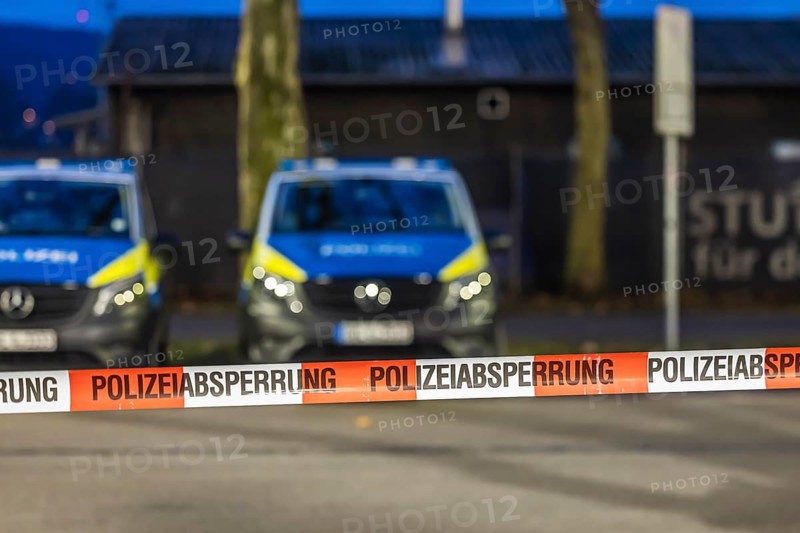 Flutter tape with the inscription police barrier. Behind them, police vehicles. Stuttgart, Baden-Württemberg, Germany