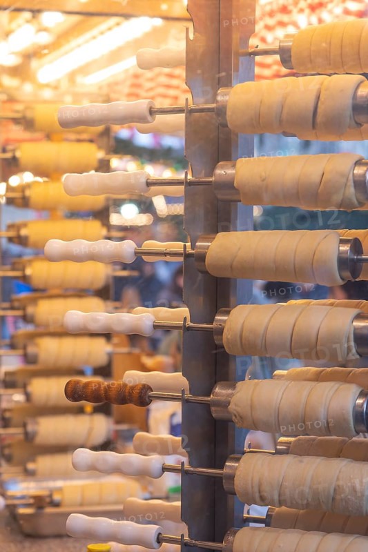 The trendy Chimney Cake stand at Stuttgart Christmas Market offers freshly baked, sweet treats. The aromatic scents attract numerous market visitors who enjoy the unique dessert