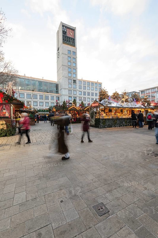 The Christmas market on the market square, in front of Stuttgart City Hall 2025, shines in festive lights in the evening. Many people visit the stands and enjoy the Christmas atmosphere