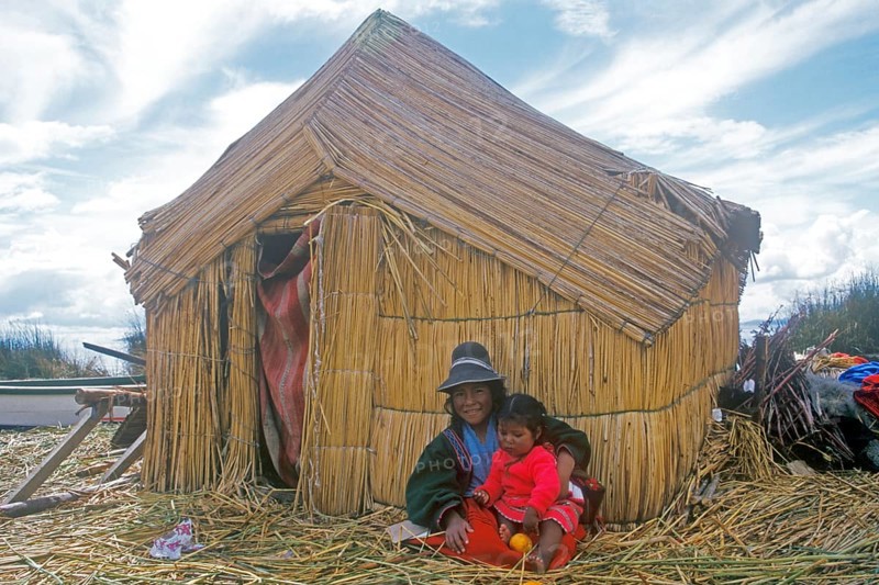 Children sitting in front of a reed hut on a floating Uro island in Lake Titcaca, Peru, South America, September 1997, vintage, retro, old, historic