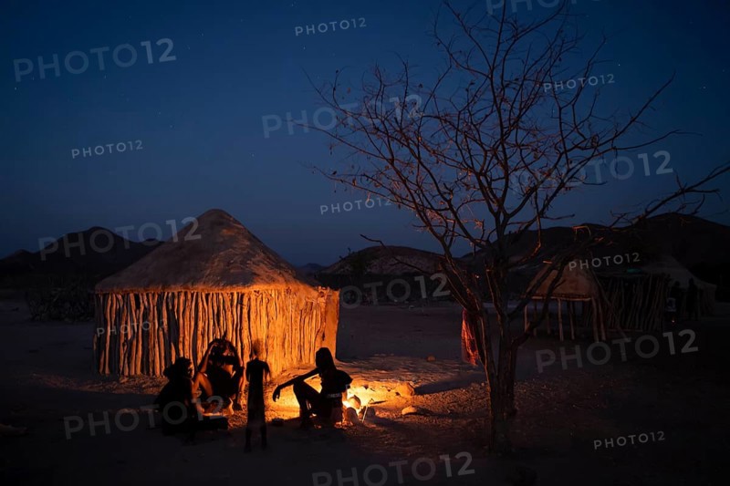 Himba at the campfire in the evening, night view, Himba huts, traditional Himba village in the savanna, Kaokoveld, Kunene, Namibia