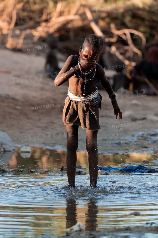 Himba child washing with water on a river, traditional Himba, Kaokoveld, Kunene, Namibia