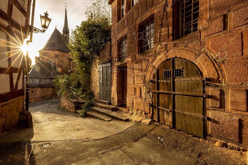 Historic alley with half-timbered houses and church in sunlight with a quiet atmosphere, The historic alleys and streets of the old town of Marburg