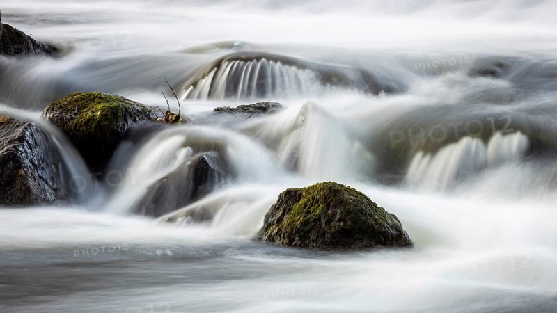 Running water over moss-covered stones in a quiet, natural environment, the small river Lahn flows over stones
