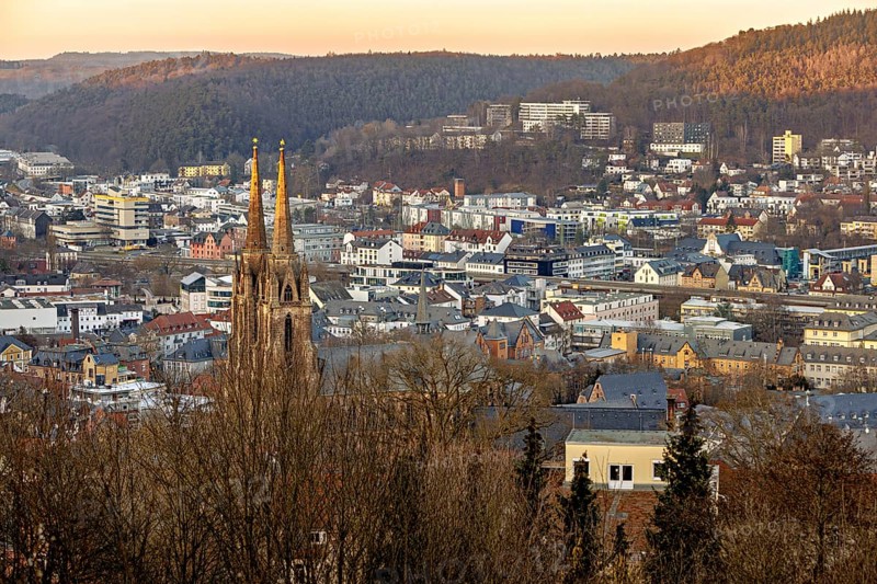 View of a town with a church and surrounding hills at sunset, view of the city of Marburg with the Elisabeth church
