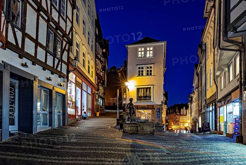 Night view of an old town street with illuminated facades and cobblestones, At the blue hour in the city center of Marburg in Hesse