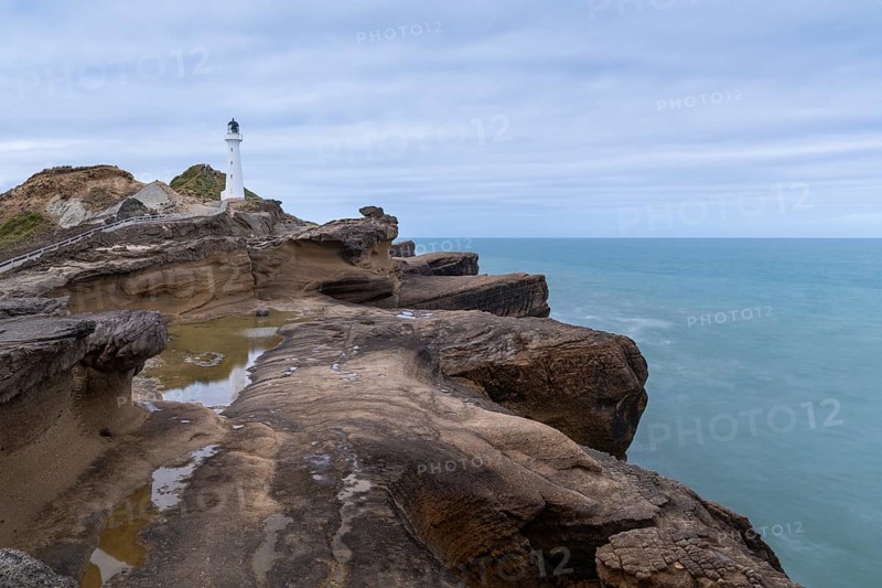 Castlepoint lighthouse on a rock, sea, long exposure. Castlepoint, Wairarapa Coast, Wellington Region, North Island, New Zealand
