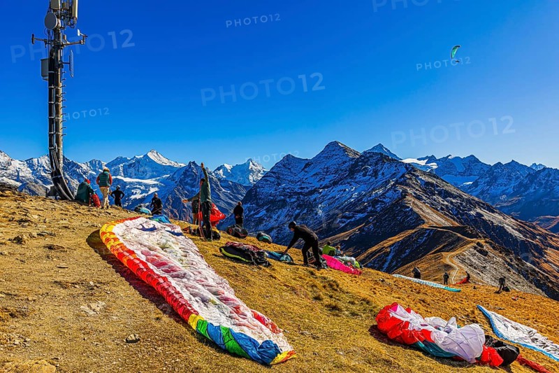 Paragliders are preparing for their start, with the snow-capped peaks of the Valais Alps, Val d'Anniviers, Canton of Valais, Switzerland
