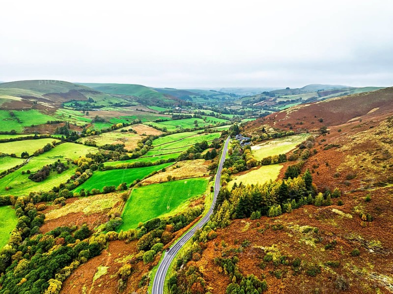 Autumn colours of Farms over River Wye and Road A470 from a drone, Llanidloes, Powys, Montgomeryshire, Wales, UK