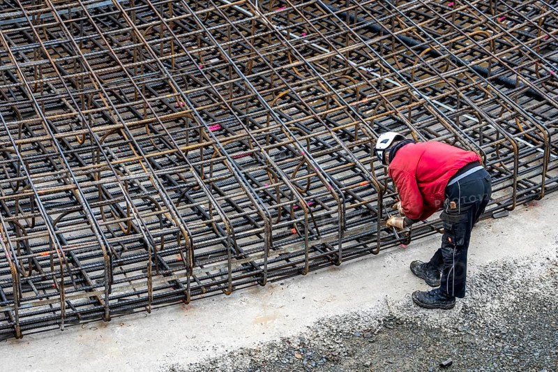 Assembly of reinforcing steel for the reinforced concrete foundation of a wind turbine, a mesh of rebar and reinforcing steel mesh, connecting the steel elements with binding wire, twisting with tongs, over 100 tons of reinforcing steel were used, the wind turbine will have a hub height of 160 meters, part of a new wind farm in Sauerland, near Balve, North Rhine-Westphalia, Germany