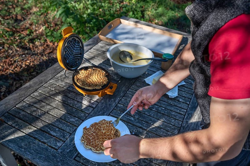 Preparation of waffles with a waffle iron on an outdoor garden table, Othenstorf, Mecklenburg-Western Pomerania, Germany