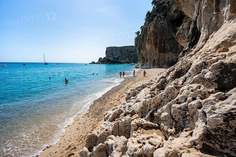 Sandy beach beach and steep cliffs at Cala Luna, Golfo di Orosei, Baunei, Sardinia, Italy
